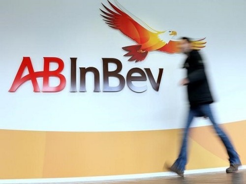 A man walks past the logo of Anheuser-Busch InBev at the brewer's headquarters in Leuven, Belgium February 26, 2014. REUTERS/Francois Lenoir/File photo
